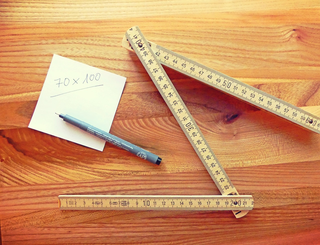 Folding wood ruler and measurement notes on a workbench